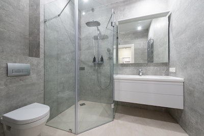 ein modernes Badezimmer mit bodentiefer Dusche und großformatigen Fliesen