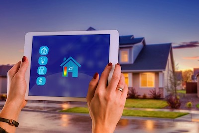 Tablet auf dem das Haus im Hintergrund als Wärmebild dargestellt wird