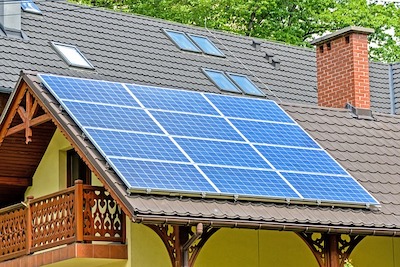 Dach eines Wohnhauses das zur Hälfte mit Solarplatten eingedeckt ist