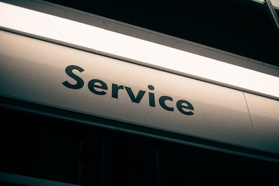 beleuchtetes Schild auf schwarzem Hintergrund mit dem Wort Service